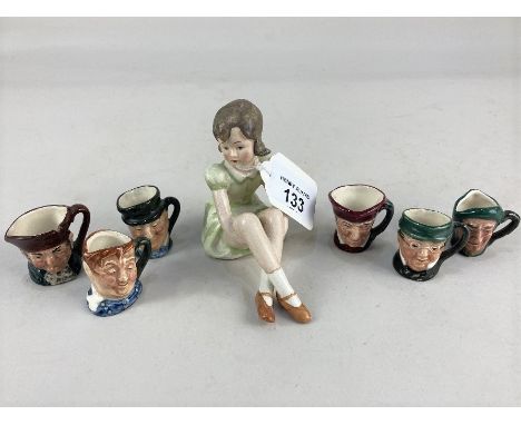 A Goebel figure of a seated girl in a green dress, 8.5cm and six Royal Doulton miniature character jugs