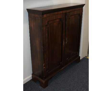 An early 19th century mahogany side cabinet with two cross banded panelled doors with line inlay, on bracket feet (a/f) 92cm