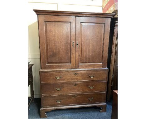 A George III oak linen press, with two panel doors enclosing a rail, the base with three drawers, on bracket feet, 130cm (top