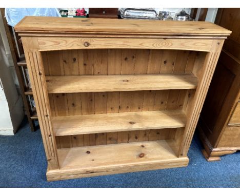 A pine three shelf bookcase, on plinth base, 107cm wide