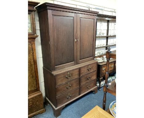 A George III mahogany linen press, with two panel doors enclosing three adjustable shelves and a row of small drawers, over s