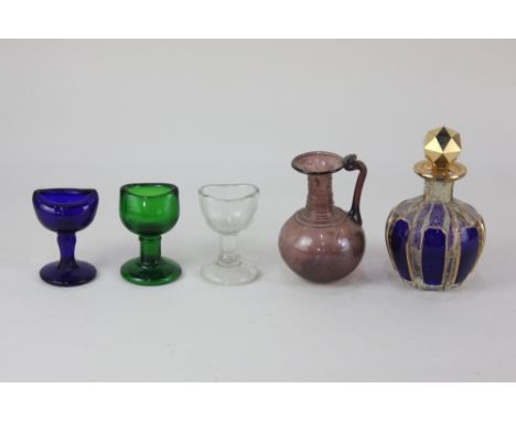 An antiquarian small amethyst glass flagon, 8.5cm high, a 19th century clear and blue glass scent bottle and stopper, with gi