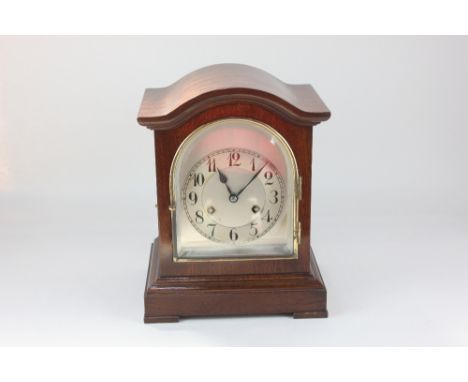 An early 20th century mahogany mantle clock, the case with arched top, dial with Arabic numerals, striking on a gong, 23.5cm,