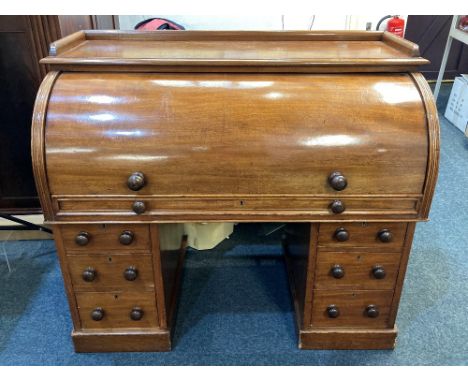 A Victorian mahogany cylinder pedestal desk with galleried shelf top, roll top cylinder fall (lock missing) enclosing sliding