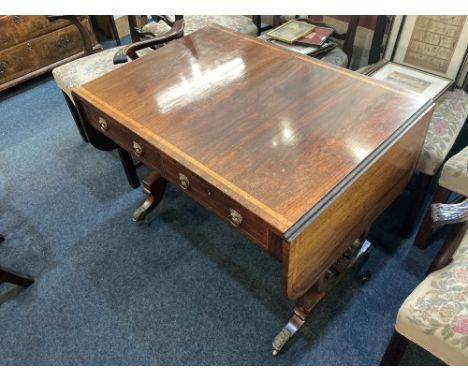 A Regency style rosewood sofa table, the rectangular cross banded drop leaf top above two drawers and opposing faux drawers, 