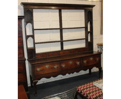 A George III oak dresser open shelf back with narrow shelves and small drawers, on base with three frieze drawers on cabriole