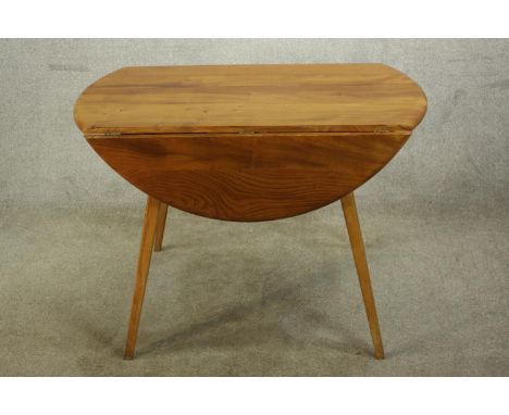 A mid 20th century blonde elm Ercol drop leaf table, raised on splayed supports. H.70 W.104 D.103cm. (Extended) 