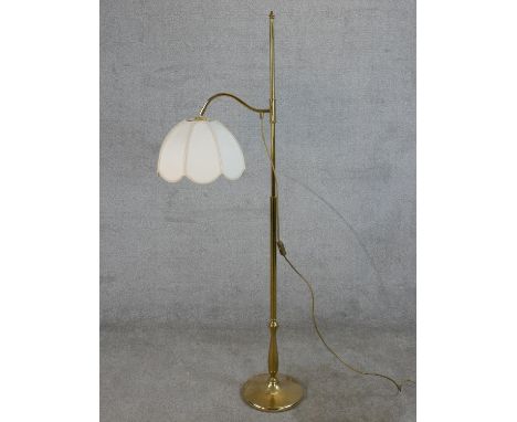 A 20th century brass adjustable standard lamp, raised on circular foot. H.152 W.45cm 