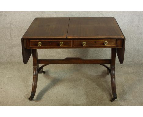 A 19th century mahogany sofa table, raised on four splayed supports terminating on brass capped feet and casters. H.72 W.153(