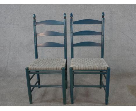 A pair of 20th century painted Shaker style ladder back chairs, raised on turned supports and stretchers, each with woven sea