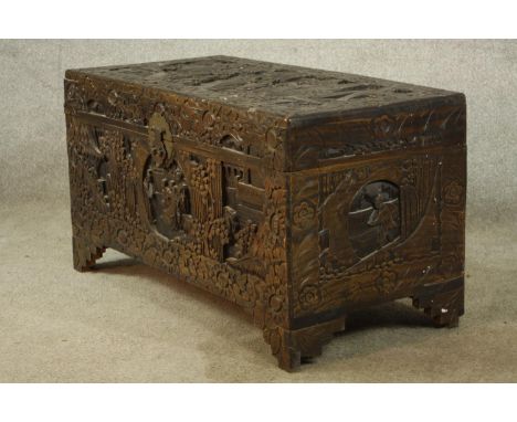 An early 20th century carved Chinese camphorwood trunk, with twin swing handles, raised on shaped bracket feet. H.48 W.89 D.4