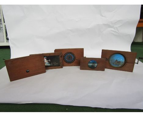 Four early 20th Century mahogany magic lantern slides, two with winding handles, the other two lever operated with another da