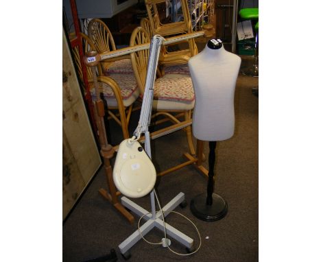 A mobile magnifying light, a clothes dummy and a tapestry frame 
