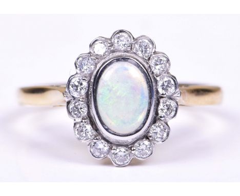 An opal and diamond cluster ringCentring an oval opal cabochon, to a round brilliant cut diamond surround, to an 18k gold sha