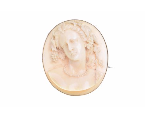 An early 20th century ivory cameo broochCarved to depict a woman in profile with long, curved grape vines in her hair, to an 