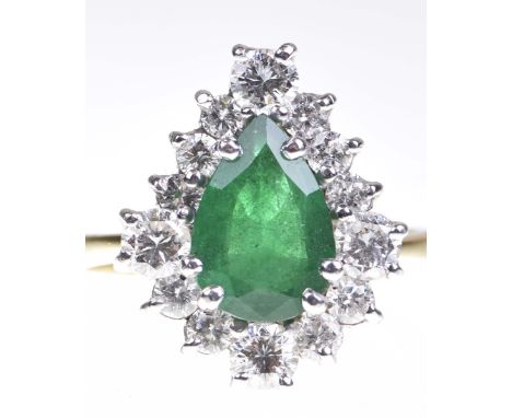 An emerald and diamond cluster ringThe pear shaped emerald to a graduated round brilliant cut diamond surround, in 18k gold, 