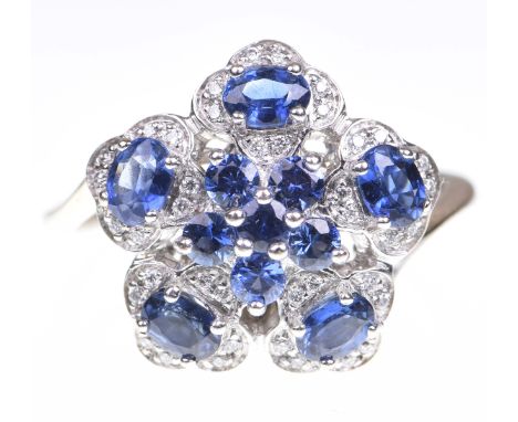 A sapphire and diamond cluster ringThe central sapphire cluster, flanked by five oval shaped sapphires, each within a round b