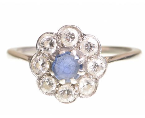 A sapphire and diamond cluster ringCentring a circular shaped sapphire to a round brilliant cut diamond surround, platinum sh