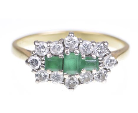 An emerald and diamond cluster ringThe central step cut emeralds, within a round brilliant cut diamond surround, to an 18k go