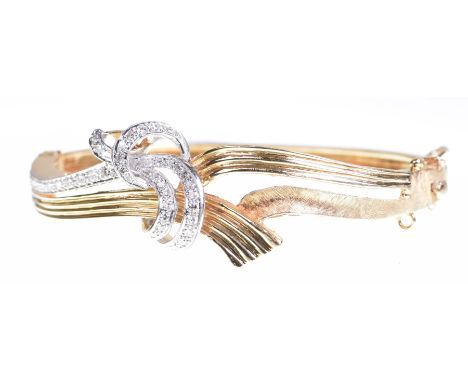 A diamond set bangleThe hinged bangle, with openwork and diamond set twist decoration, textured and reeded metal throughout, 