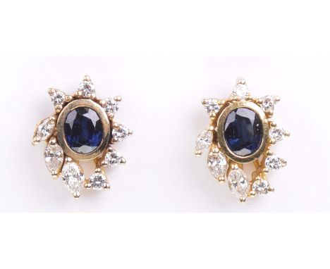 A pair of sapphire and diamond ear studsThe oval shaped bezel set sapphire, to a round brilliant cut and marquise cut diamond