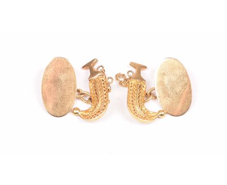 A pair of cufflinksDesigned as a filigree sheath and dagger, with a chain link and plain oval panel, unmarked, length 2.2cm