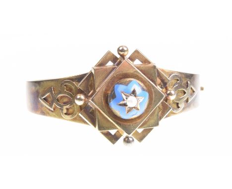 A Victorian gold child's christening hinged bangle, circa 1880The central domed and geometric motif, with blue enamel detail 