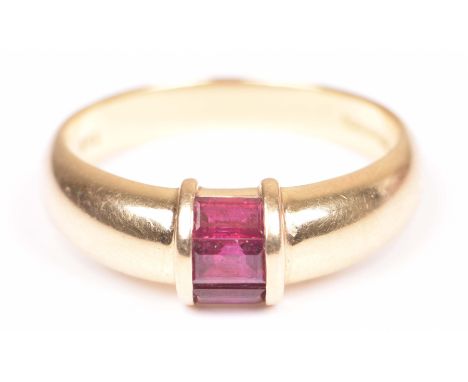Tiffany & Co.: An 18k gold and ruby ringSet with three step-cut rubies, to a tapering plain 18k gold band, signed Tiffany & C