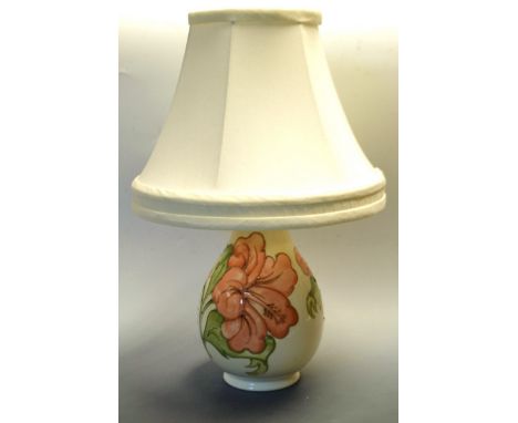 A Moorcroft Hibiscus pattern table lamp, tubelined with large flowerhead, in tones of peach and green on a white ground, impr