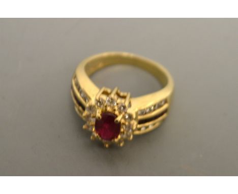 A ruby and diamond cluster ring, central red ruby, approx 0.80ct, surrounded by a band of twelve round brilliant cut diamonds