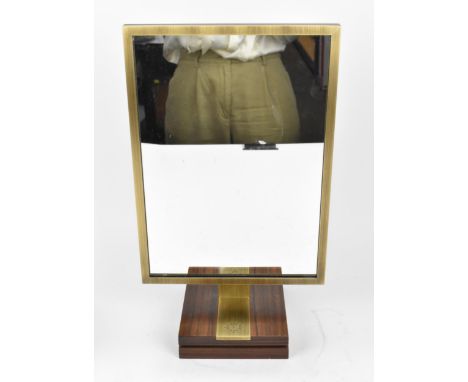 A Patek Philippe brass and hardwood mounted mirror, with hinged easel back, 38 cm high 