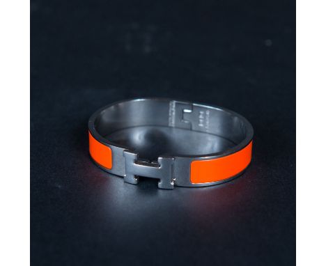 Bracelet in box. Metal chromed, orange enamel, close up in function , oval shape . 6,2x5,2 cm 