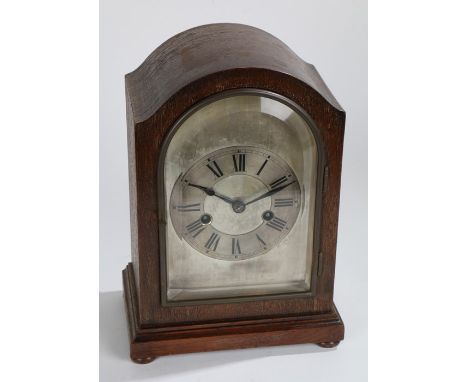 Early 20th Century oak cased mantel clock, having a glazed door enclosing a silvered dial with roman numerals, twin train mov