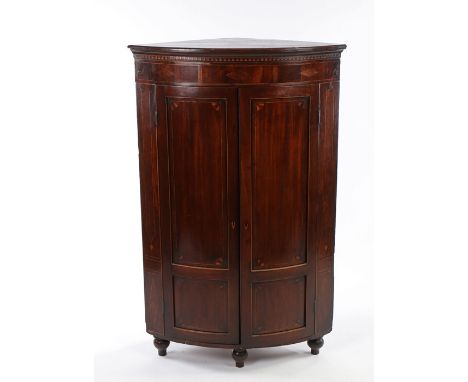 George III mahogany and boxwood strung standing corner cabinet, the bow front with a pair of doors enclosing shaped shelves a