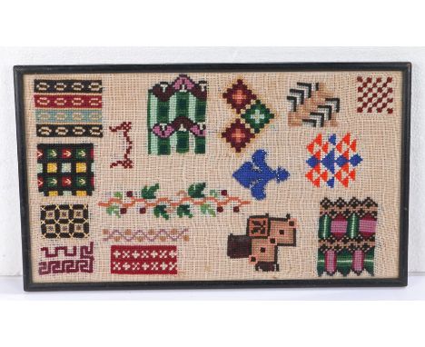 Berlin woolwork sampler style panel, decorated with various woolwork patterns, housed in a glazed ebonised frame, 37.5cm wide