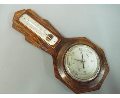 An aneroid barometer and thermometer mounted on an English oak art deco frame, 39 cm (high) This lot must be paid for and col
