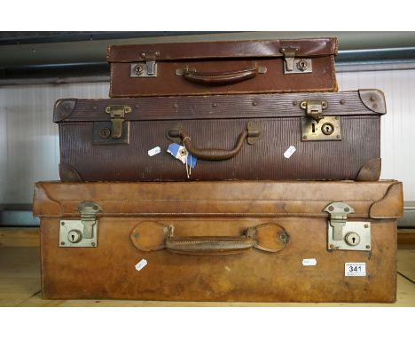 A collection of three vintage suitcases to include a brown leather example. 