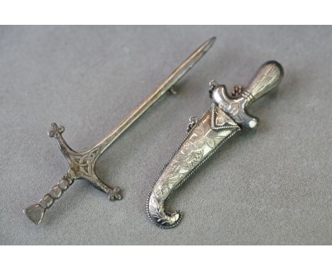 A Scottish hallmarked sterling silver sword brooch together with a white metal dagger brooch. 