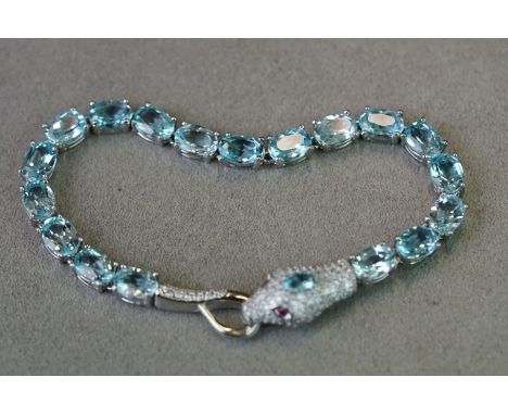 Impressive silver and blue topaz line bracelet with snake head clasp and ruby eyes 