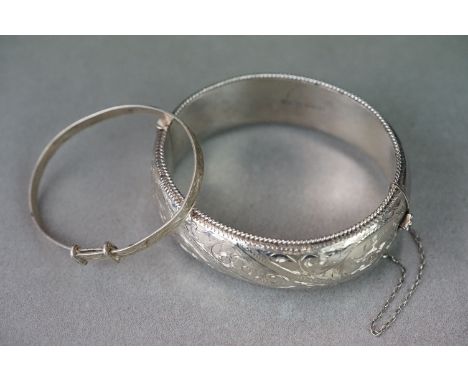 A fully hallmarked sterling silver cuff bangle together with a silver christening bangle. 