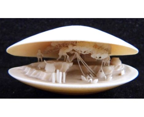 Early 20th century Japanese carved ivory clam shell with figures in a landscape interior, signed to base, 6cm wide,PLEASE NOT