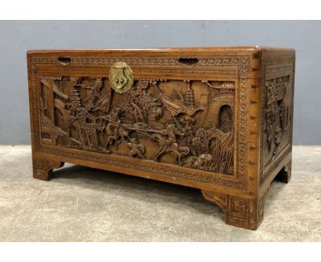 Early 20th century Chinese camphorwood coffer, the cover, front and sides carved with figures in a landscape, on bracket feet