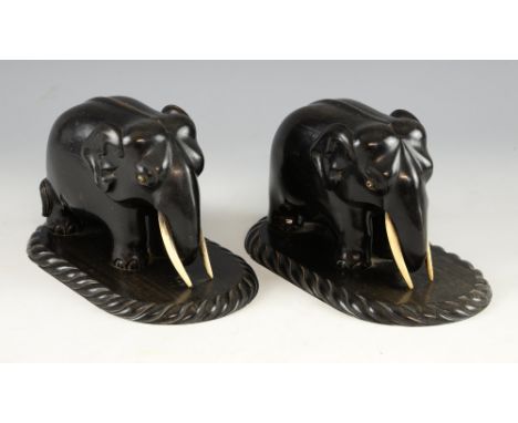 Pair of 19th century carved ebony elephants with ivory tusks and eyes on integral oval carved bases, 12cm high,PLEASE NOTE: T