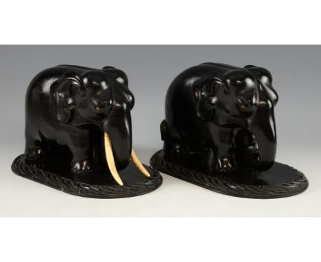 Pair of 19th century carved ebony elephants with ivory tusks and eyes on integral oval carved bases, 19.5cm high, PLEASE NOTE