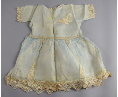 A vintage cane hamper containing a quantity of Victorian and later baby and dolls' clothing, mainly in white cotton, together