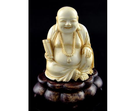 19th century Japanese carved ivory Buddha, holding a scroll in one hand, on wood base, the figure, Meiji period, 10.5 cms hig