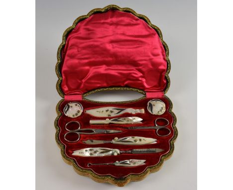 Manicure set, the carved mother of pearl handles leaf form and with gilt floral decoration, full set including rouge pots and