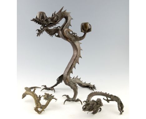 REVISED ESTIMATE: Chinese cast bronze two light candelabra in the form of a dragon rearing up on it's hind legs, 39cm high, a