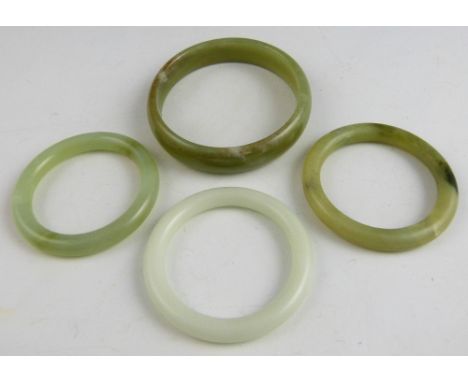 Chinese white jade bangle 8cm diameter, and three pale celadon and mottled jade bangles, various sizes, (4),.   