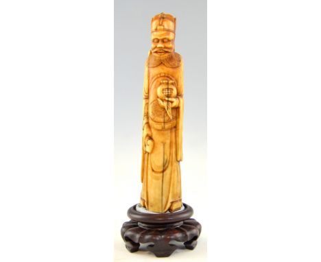 Early 20th century Chinese carved ivory figure of a bearded man holding a pomegranate, 14cm high, on later non-matching woode